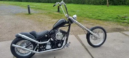 Bobber met wit zadel naast de bus van Bart’s Bike Shop