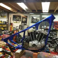 Chopper met blauw vlammenlakwerk voor een bakstenen gevel