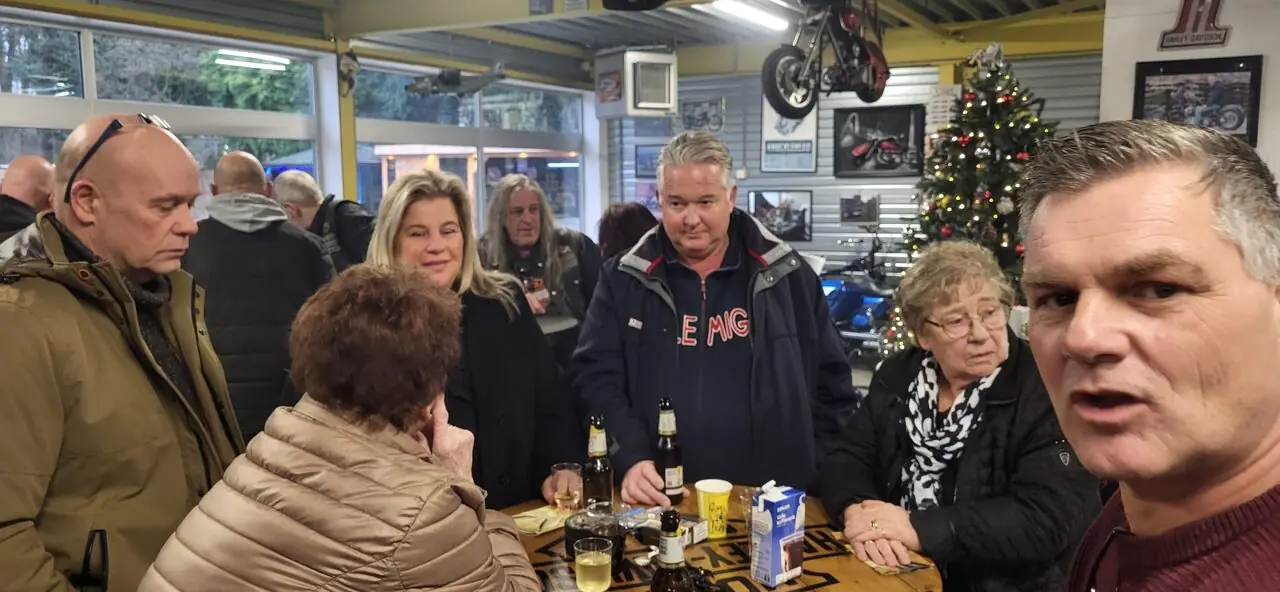 Groep bezoekers aan tafel tijdens de oudejaarsborrel