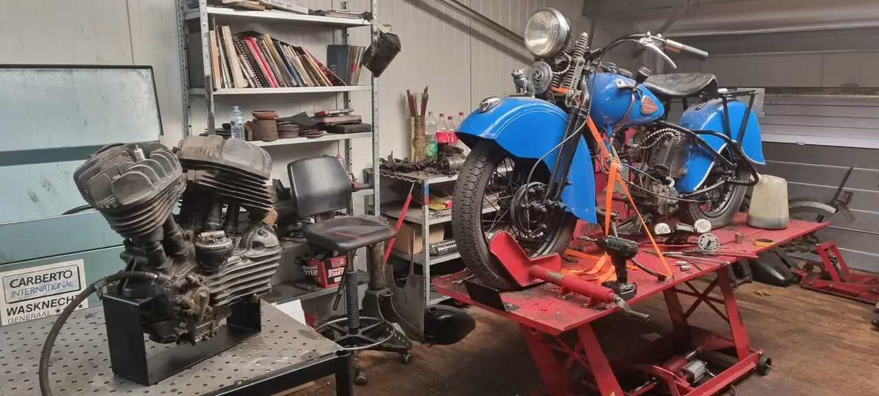 Klassieke motor in restauratie met het oude blok los op de werkbank